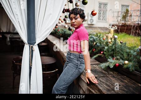 Jeune femme afro-américaine urbaine en haut rose et jeans gris. Afro mode chic femmes. Banque D'Images