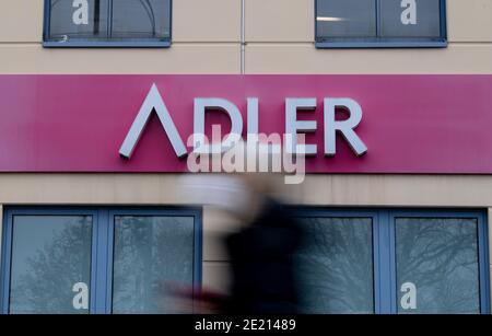 Berlin, Allemagne. 11 janvier 2021. Une femme avec le nez-à-nez couvrant marche après un signe de la compagnie 'Adler Modemärkte' dans un centre commercial. L'insolvabilité du détaillant de mode international Adler Modemärkte prend son cours: Lundi, le tribunal régional d'Aschaffenburg a confirmé la réception d'une demande d'insolvabilité de la part d'Adler Modemärkte AG. Un expert avait été chargé d'examiner s'il serait possible de gérer l'insolvabilité sous la responsabilité propre de la société. Credit: David Hutzler/dpa/Alay Live News Banque D'Images