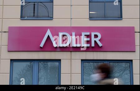 Berlin, Allemagne. 11 janvier 2021. Une femme avec le nez-à-nez couvrant marche après un signe de la compagnie 'Adler Modemärkte' dans un centre commercial. L'insolvabilité du détaillant de mode international Adler Modemärkte prend son cours: Lundi, le tribunal régional d'Aschaffenburg a confirmé la réception d'une demande d'insolvabilité de la part d'Adler Modemärkte AG. Un expert avait été chargé d'examiner s'il serait possible de gérer l'insolvabilité sous la responsabilité propre de la société. Credit: David Hutzler/dpa/Alay Live News Banque D'Images