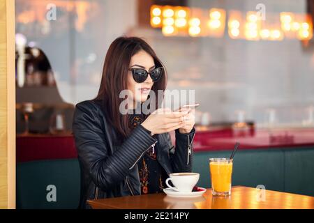 Femme blogger prenant la photo du café avec le téléphone mobile Banque D'Images