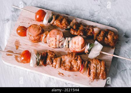 Photo aérienne de rouleaux de viande de champignons enoki dans des brochettes une planche en bois Banque D'Images