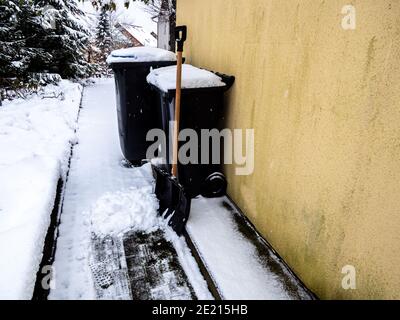 Retirez la neige des poubelles Banque D'Images