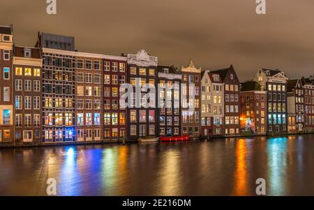 Maisons typiques sur le Damrak la nuit, à Amsterdam, aux pays-Bas Banque D'Images