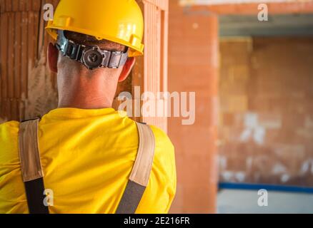 Travailleur caucasien portant un casque de sécurité à tête jaune. Zone du chantier de construction de casque dur. Sécurité sur le site. Banque D'Images