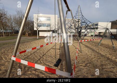 Jena, Allemagne. 11 janvier 2021. Une aire de jeux pour enfants dans le quartier résidentiel de Lobeda est dotée de bandes rouges et blanches. L'administration de la ville a interdit l'utilisation des terrains de jeux pour enfants. Credit: Bodo Schackow/dpa-Zentralbild/dpa/Alay Live News Banque D'Images