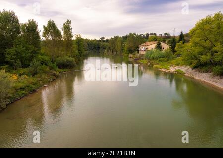 Vue sur la rivière Ter qui passe par Sant Hipolito de Voltrega, où les arbres qui la bordent se reflètent dans ses eaux calmes un jour d'été. Banque D'Images