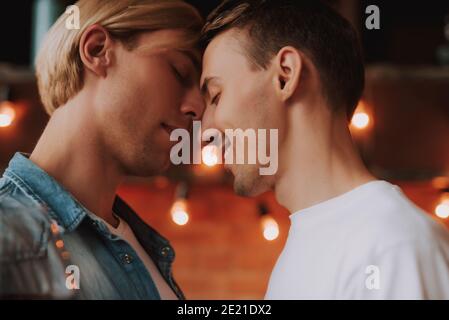Couple gay aimant à la maison. Deux beaux hommes qui embrasent et embrassaient la cuisine. Concept LGBT. Banque D'Images