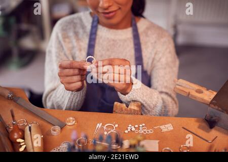 Gros plan de la femme Jeweler au banc de vérification bague elle Est en cours d'utilisation dans Studio Banque D'Images