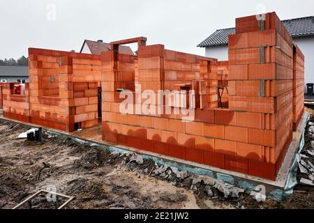 Chantier de construction avec le début d'une coquille de brique maçonnerie en béton pour une maison familiale Banque D'Images