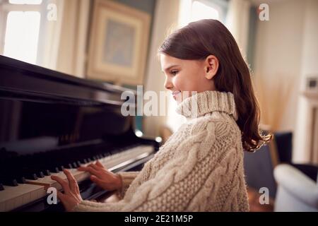 Jeune fille apprendre à jouer au piano à la maison Banque D'Images