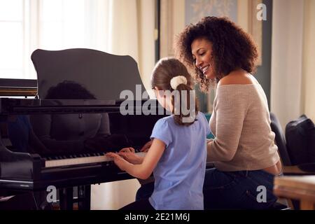 Jeune fille apprendre à jouer du piano ayant une leçon de femme Enseignant Banque D'Images