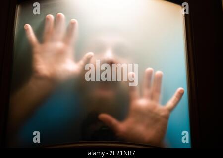 tableau effrayant des mains derrière le verre Banque D'Images