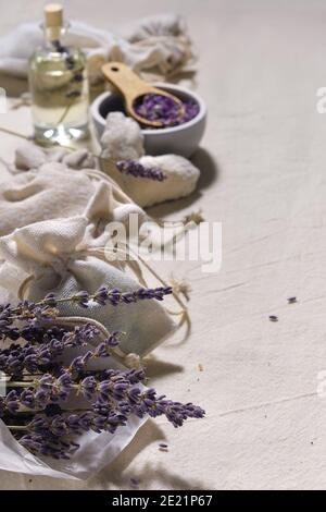 Sachets de lavande faits à la main dans des sacs textiles et coeurs de coton sur nappe de coton. Style de vie naturel à faible impact. Fleurs de lavande sèches dans le papier à tracer Banque D'Images