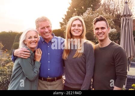Portrait de famille avec des parents adultes avec un fils adulte Et fille à l'extérieur contre Flaring Sun Banque D'Images