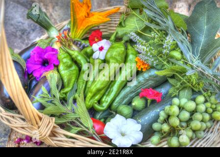 Mise au point sélective de divers légumes mûrs dans un panier avec de jolies fleurs Banque D'Images