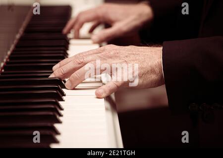 Mise au point sélective des mains de l'homme jouant du piano Banque D'Images