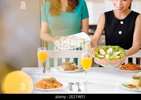 Femme servant une table de dîner Banque D'Images