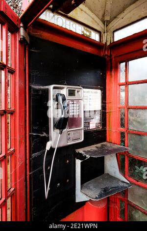 Intérieur rouge de la boîte téléphonique britannique avec téléphone public Banque D'Images