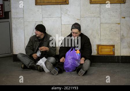 Vivre sur la ligne de pain. Deux hommes sans abri qui mangent dans un passage souterrain se cachant du mauvais temps. 12 janvier 2012. Kiev, Ukraine. Banque D'Images