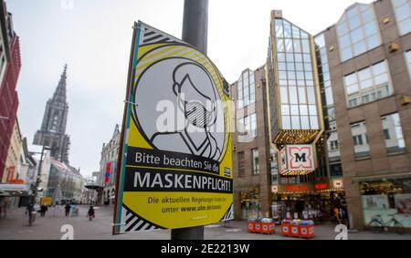 11 janvier 2021, Baden-Wuerttemberg, Ulm: Un panneau dans la zone piétonne devant un grand magasin ouvert de la chaîne de pharmacie Müller souligne l'obligation de masque. Photo: Stefan Puchner/dpa Banque D'Images