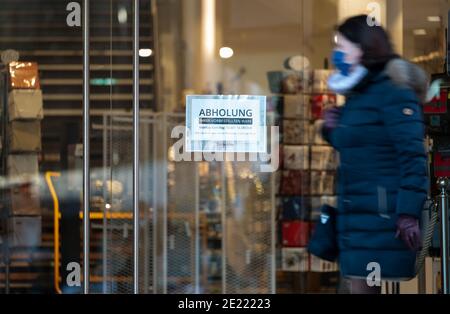 11 janvier 2021, Bade-Wurtemberg, Stuttgart : un panneau portant l'inscription « Abholung » (prise en charge) est accroché à l'entrée du magasin d'articles ménagers Tritschler. Depuis le 11 janvier, la grande majorité des entreprises du sud-ouest sont de nouveau autorisées à faire collecter leurs marchandises sur place par des clients si leurs commandes ont déjà été passées par téléphone ou en ligne, par exemple. Photo: Marijan Murat/dpa Banque D'Images