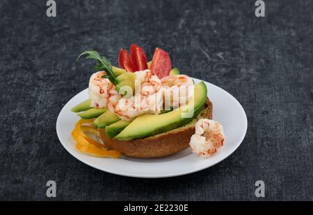 Sandwich sur un pain de seigle avec avocat, crevettes et tomate, vue de dessus, faible profondeur de la netteté Banque D'Images