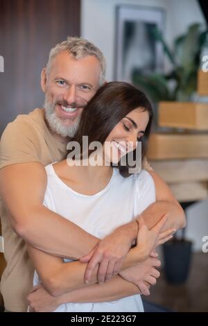 Homme barbu et jeune femme qui s'embrasse et qui a l'air heureux Banque D'Images