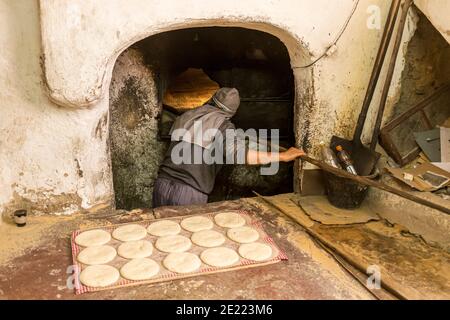 Baker boulangerie Maroc petits pains plats connus sous le nom de khobz. Chaque quartier de la médina dispose d'un four à pain commun. Banque D'Images