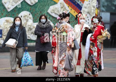 Les femmes portant des kimono et des masques qui passent du temps à Shibuya Crossing pendant la journée « Coming of Age » en Tokyo.Coming de la Journée de l'âge célèbre ceux qui ont atteint l'âge de 20 ans. C'est un jour férié le deuxième lundi de janvier au Japon. Cependant, à la lumière du taux croissant d'infection par COVID19 au Japon, le jour de l'âge de 2021 n'était pas le même comme d'habitude. La cérémonie officielle n'était en ligne que dans la plupart des bureaux de la ville au Japon. Dans la place populaire Shibuya Crossing n'était que peu de filles dans le magnifique kimono. Toutes les personnes portant un masque. Banque D'Images
