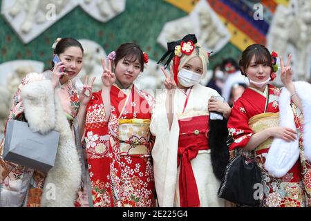 Les femmes portant des kimono et des masques qui passent du temps à Shibuya Crossing pendant la journée « Coming of Age » en Tokyo.Coming de la Journée de l'âge célèbre ceux qui ont atteint l'âge de 20 ans. C'est un jour férié le deuxième lundi de janvier au Japon. Cependant, à la lumière du taux croissant d'infection par COVID19 au Japon, le jour de l'âge de 2021 n'était pas le même comme d'habitude. La cérémonie officielle n'était en ligne que dans la plupart des bureaux de la ville au Japon. Dans la place populaire Shibuya Crossing n'était que peu de filles dans le magnifique kimono. Toutes les personnes portant un masque. Banque D'Images