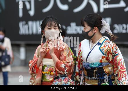 Les femmes portant des kimono et des masques qui passent du temps à Shibuya Crossing pendant la journée « Coming of Age » en Tokyo.Coming de la Journée de l'âge célèbre ceux qui ont atteint l'âge de 20 ans. C'est un jour férié le deuxième lundi de janvier au Japon. Cependant, à la lumière du taux croissant d'infection par COVID19 au Japon, le jour de l'âge de 2021 n'était pas le même comme d'habitude. La cérémonie officielle n'était en ligne que dans la plupart des bureaux de la ville au Japon. Dans la place populaire Shibuya Crossing n'était que peu de filles dans le magnifique kimono. Toutes les personnes portant un masque. Banque D'Images