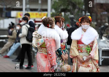 Les femmes portant des kimono et des masques qui passent du temps à Shibuya Crossing pendant la journée « Coming of Age » en Tokyo.Coming de la Journée de l'âge célèbre ceux qui ont atteint l'âge de 20 ans. C'est un jour férié le deuxième lundi de janvier au Japon. Cependant, à la lumière du taux croissant d'infection par COVID19 au Japon, le jour de l'âge de 2021 n'était pas le même comme d'habitude. La cérémonie officielle n'était en ligne que dans la plupart des bureaux de la ville au Japon. Dans la place populaire Shibuya Crossing n'était que peu de filles dans le magnifique kimono. Toutes les personnes portant un masque. Banque D'Images