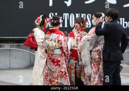 Les femmes portant des kimono et des masques qui passent du temps à Shibuya Crossing pendant la journée « Coming of Age » en Tokyo.Coming de la Journée de l'âge célèbre ceux qui ont atteint l'âge de 20 ans. C'est un jour férié le deuxième lundi de janvier au Japon. Cependant, à la lumière du taux croissant d'infection par COVID19 au Japon, le jour de l'âge de 2021 n'était pas le même comme d'habitude. La cérémonie officielle n'était en ligne que dans la plupart des bureaux de la ville au Japon. Dans la place populaire Shibuya Crossing n'était que peu de filles dans le magnifique kimono. Toutes les personnes portant un masque. Banque D'Images