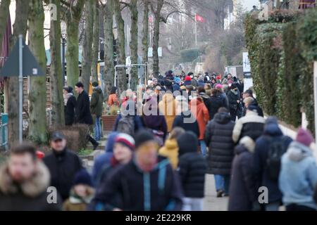 Hambourg, Allemagne. 10 janvier 2021. En perspective, dessinées ensemble à travers un téléobjectif, les gens peuvent être vus sur leur chemin ou de l'Elbe à Hambourg-Övelgönne par beau temps. Credit: Bodo Marks/dpa - ATTENTION: Utiliser seulement en format complet/dpa/Alay Live News Banque D'Images