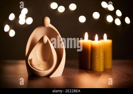 Berceau de Noël avec trois bougies et lumières de fées Banque D'Images