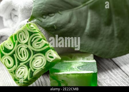 Composition de spa avec une barre de savon fait à la main, des serviettes et une grande feuille. Concept de santé et beauté. Banque D'Images