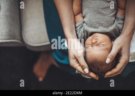 Vue du dessus photo d'une mère caucasienne tenant son nouveau-né fille sur les genoux pendant qu'elle dort Banque D'Images