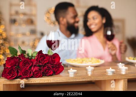 Homme noir ayant dîner avec la femme, se concentrer sur les roses Banque D'Images