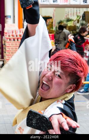 Hinokuni Yosakoi festival de danse avec le visage de la danseuse japonaise, contact visuel avec le spectateur, bouche ouverte, chant, tient naruko. Flou de mouvement Banque D'Images