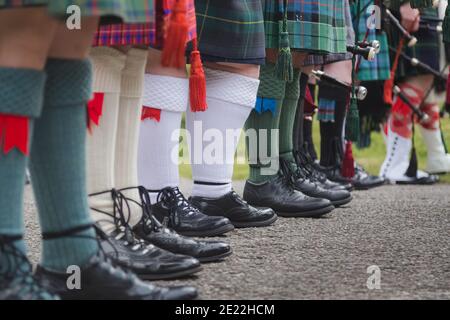 Une rangée de cornemuses écossaises vues de la taille vers le bas montrent leur tenue masculine écossaise traditionnelle. Banque D'Images