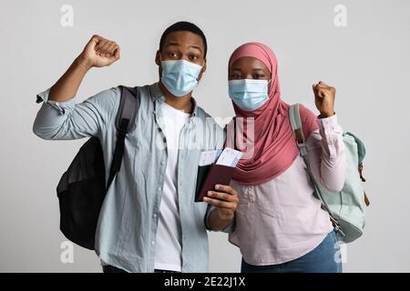 Touristes africains couple musulman portant masques protecteurs montrant des billets Banque D'Images