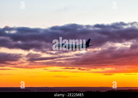 Un avion de ligne de passagers du matin débarque sur fond de ciel coloré à l'aube. Silhouette de plan de jet Banque D'Images