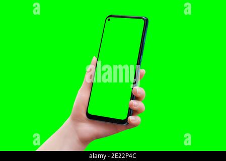 Maquette de téléphone chez une femme isolée à la main en vert couleur. Douce main de femme retouchée Banque D'Images