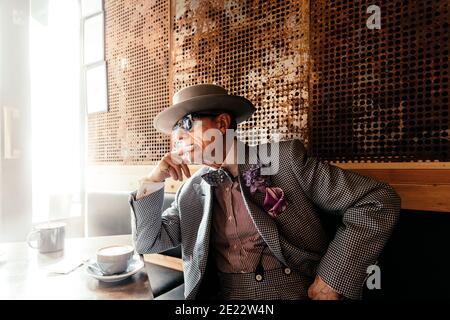 L'artiste George Skeggs (alias « soho George ») se détend dans le café My place Soho, Berwick St, Soho, Londres, Angleterre, Royaume-Uni Banque D'Images