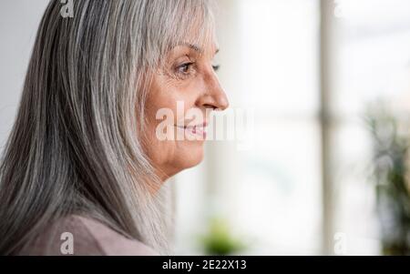 Portrait de la femme âgée debout à l'intérieur à la maison. Copier l'espace. Banque D'Images