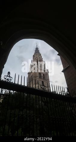 Vue sur la tour principale de la cathédrale de Tolède avec rétroéclairage clôture pendant une journée nuageux Banque D'Images