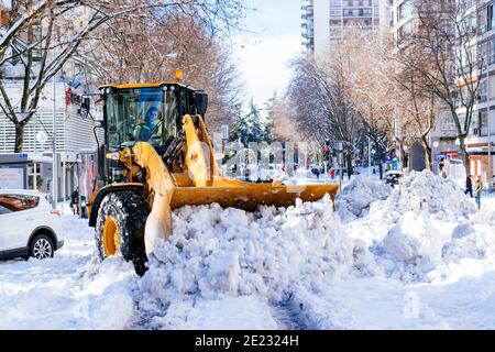 Un creuseur de CAT nettoie Alberto Alcocer la rue de neige. Le lendemain des fortes chutes de neige de Filomena. Madrid, Espagne Banque D'Images