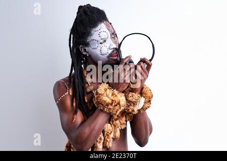 l'homme indigène africain a le goût du casque, le liche, l'utilise mal. l'homme dans l'origine ethnique porter isolé sur fond blanc Banque D'Images