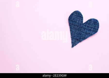 Coeur en denim bleu sur fond rose clair. Carte de Saint-Valentin avec espace de copie Banque D'Images