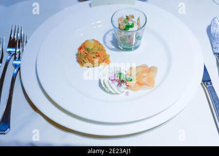 Cuisine servie. Plat avec filet de poisson et brocoli rôti avec sauce épicée dans une assiette blanche isolée. Portion de nourriture de restaurant, délicieux dîner, plat principal. Photo de haute qualité Banque D'Images